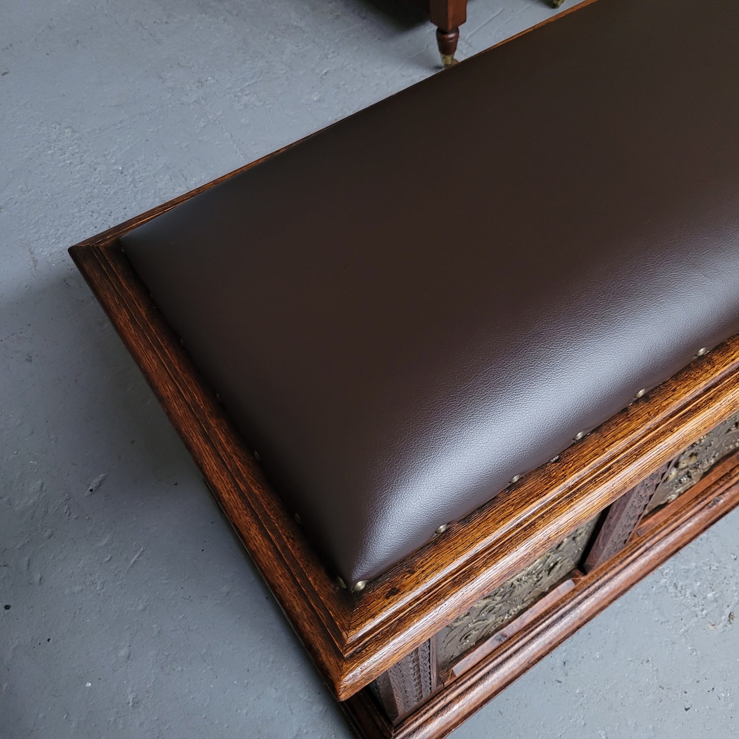 Antique French Oak coffer featuring decorative brass panels and a faux leather top. Brass panels are highly decorative featuring cherubs&nbsp; and faux leather in good used condition with very small signs of wear