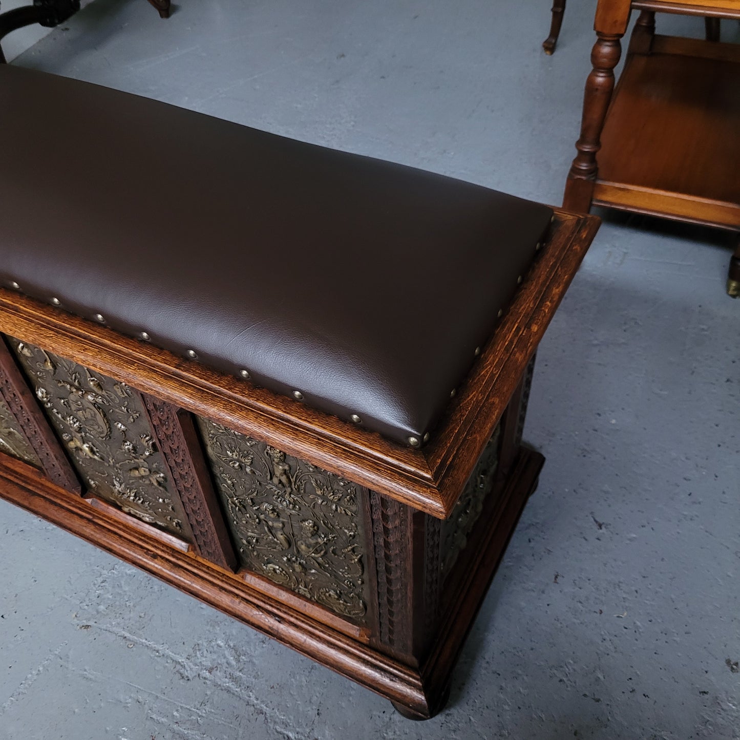 Antique French Oak coffer featuring decorative brass panels and a faux leather top. Brass panels are highly decorative featuring cherubs&nbsp; and faux leather in good used condition with very small signs of wear