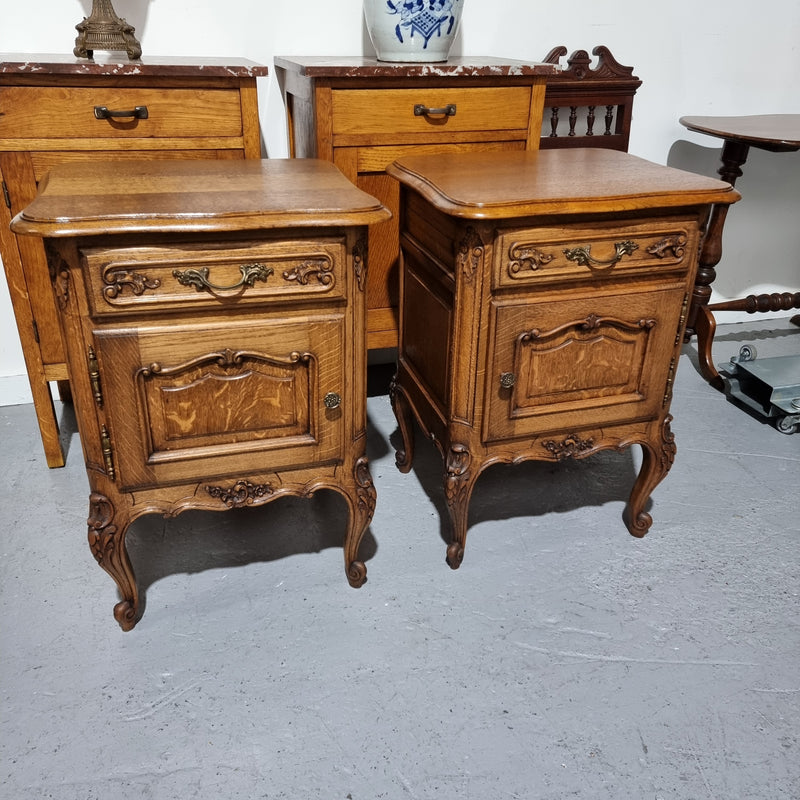 A Rare pair of Antique French Oak Louis XV style wooden top bedside cabinets. Featuring decorative carvings and classical Louis XV cabriole legs. These have been sourced directly from France and are in good original detailed condition.