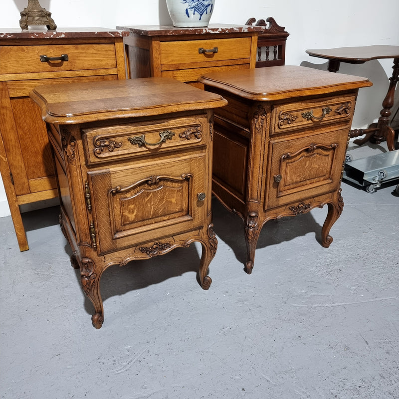 A Rare pair of Antique French Oak Louis XV style wooden top bedside cabinets. Featuring decorative carvings and classical Louis XV cabriole legs. These have been sourced directly from France and are in good original detailed condition.