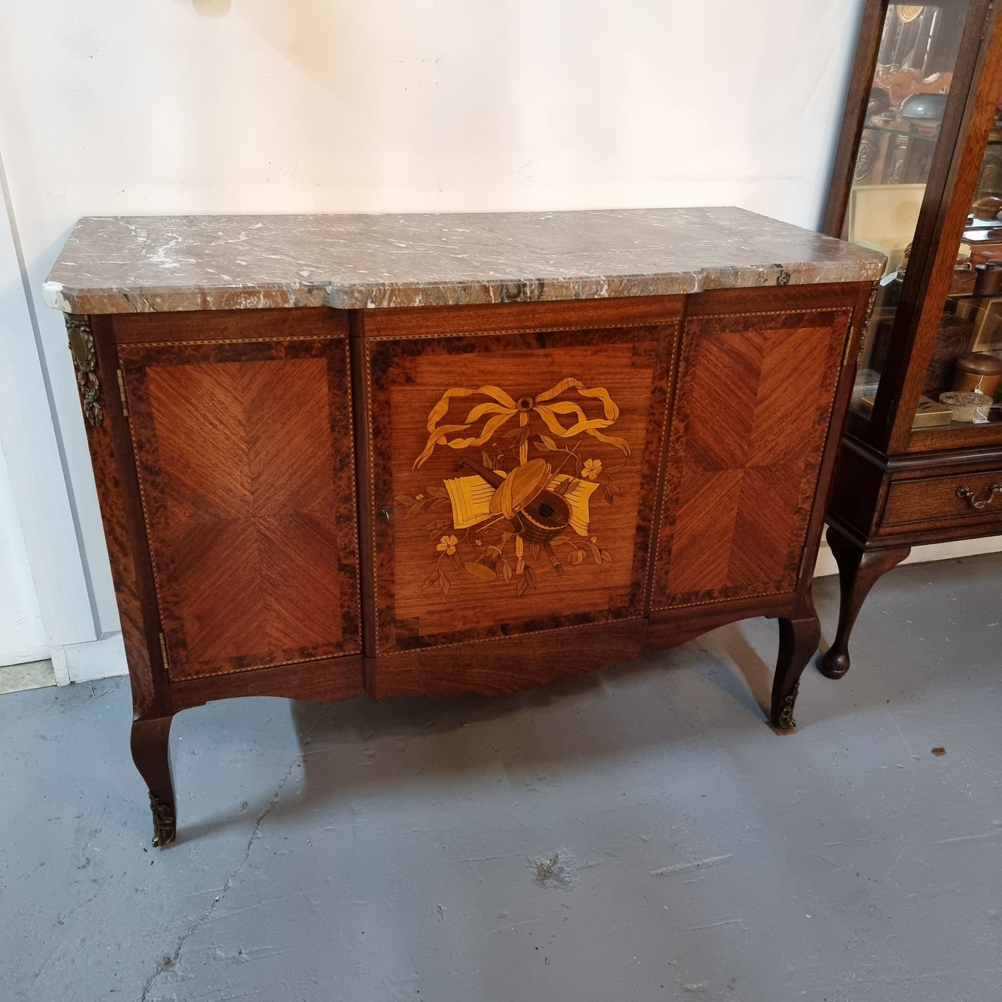 Antique late 19th century Transitional style marble top cabinet featuring beautiful marquetry inlay and decorative mounts. Made from French Walnut and Burr Walnut. In good original detailed condition. 