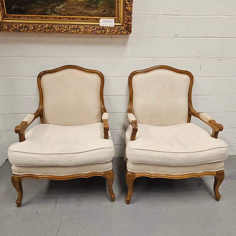 Pair of vintage Louis 15th style oak framed bergeres chairs with good size seats. making them very comfortable to sit in. The upholstery is in used condition with stains as shown in photos. Overall the timber frames are strong &amp; solid. They have been sourced directly from France. 