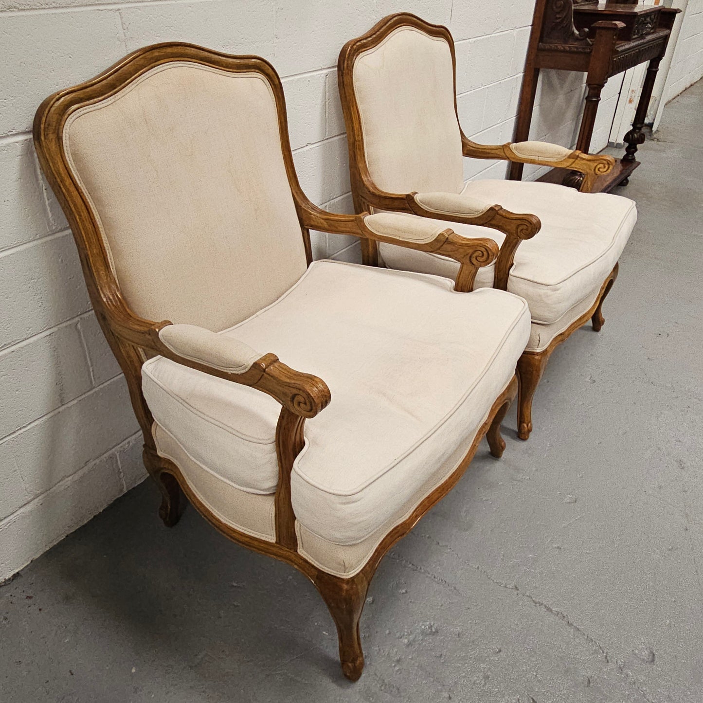 Pair of vintage Louis 15th style oak framed bergeres chairs with good size seats. making them very comfortable to sit in. The upholstery is in used condition with stains as shown in photos. Overall the timber frames are strong &amp; solid. They have been sourced directly from France. 