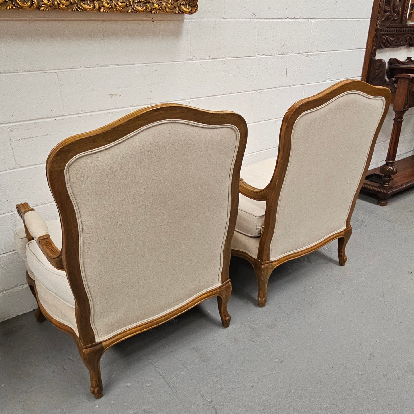 Pair of vintage Louis 15th style oak framed bergeres chairs with good size seats. making them very comfortable to sit in. The upholstery is in used condition with stains as shown in photos. Overall the timber frames are strong &amp; solid. They have been sourced directly from France. 