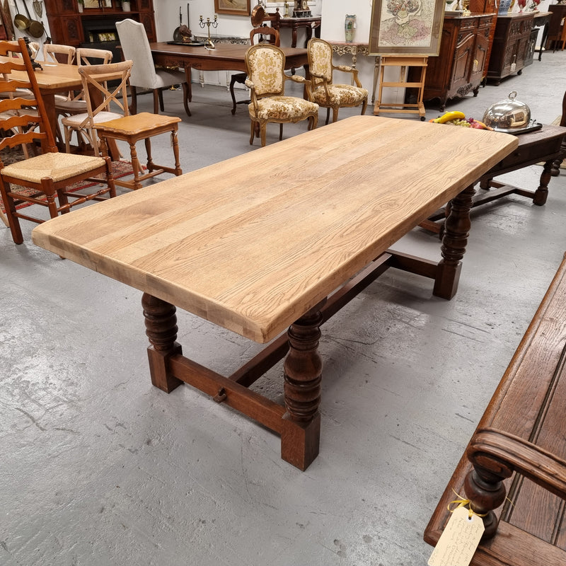 Sourced from France a solid French Oak farmhouse dining table. It features a beautiful stretcher base with turned legs and a raw oak top. The raw oak timber top could be used as is for a distressed look, or finished and waxed for a more refined look. The table very comfortably sits six people and is in good condition.