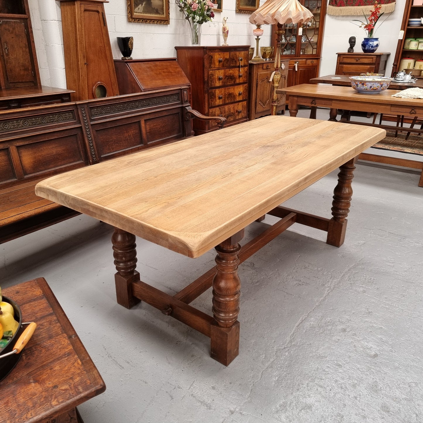 Sourced from France a solid French Oak farmhouse dining table. It features a beautiful stretcher base with turned legs and a raw oak top. The raw oak timber top could be used as is for a distressed look, or finished and waxed for a more refined look. The table very comfortably sits six people and is in good condition.