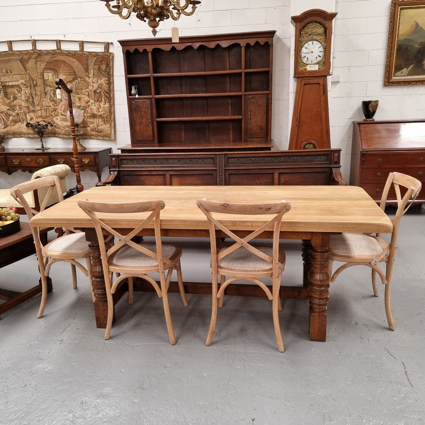 Sourced from France a solid French Oak farmhouse dining table. It features a beautiful stretcher base with turned legs and a raw oak top. The raw oak timber top could be used as is for a distressed look, or finished and waxed for a more refined look. The table very comfortably sits six people and is in good condition.