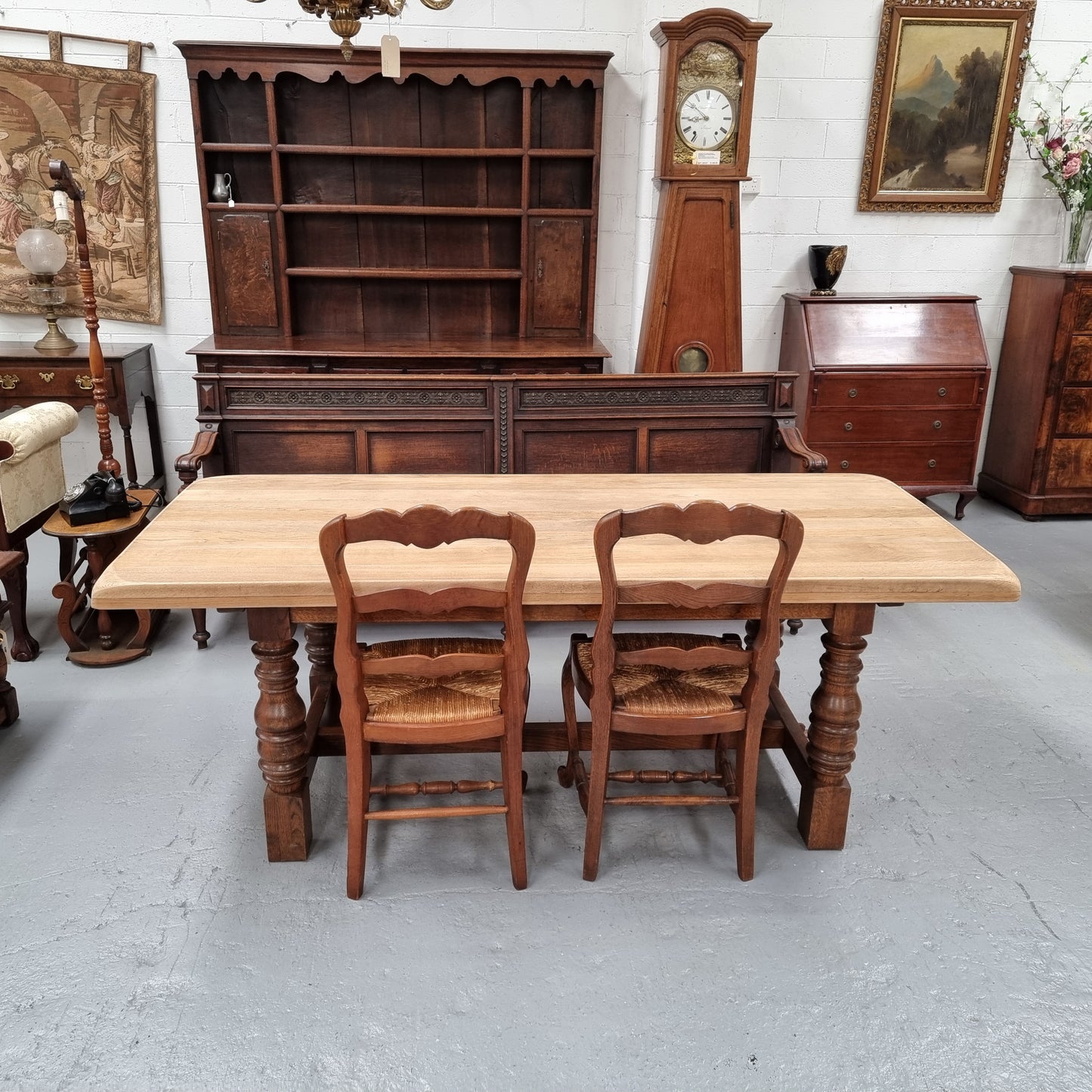 Sourced from France a solid French Oak farmhouse dining table. It features a beautiful stretcher base with turned legs and a raw oak top. The raw oak timber top could be used as is for a distressed look, or finished and waxed for a more refined look. The table very comfortably sits six people and is in good condition.