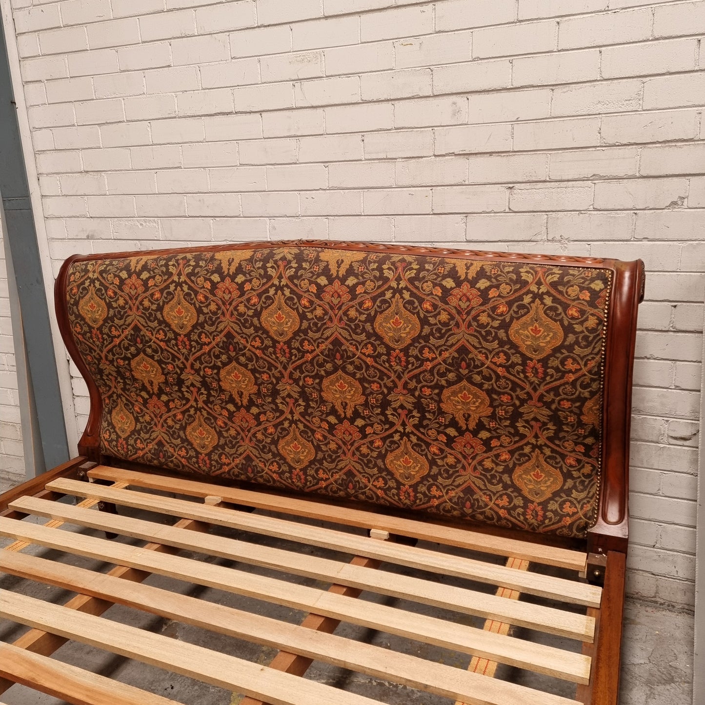 Vintage Empire style hard to find king Size bed with impressive tapestry upholstery. It comes with custom made bed slats ready to simple place your standard king size mattress on top. It is in good original detailed condition. The tapestry upholstery is in good condition and is upholstered on the back as well.