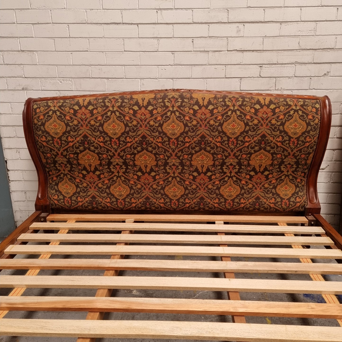 Vintage Empire style hard to find king Size bed with impressive tapestry upholstery. It comes with custom made bed slats ready to simple place your standard king size mattress on top. It is in good original detailed condition. The tapestry upholstery is in good condition and is upholstered on the back as well.