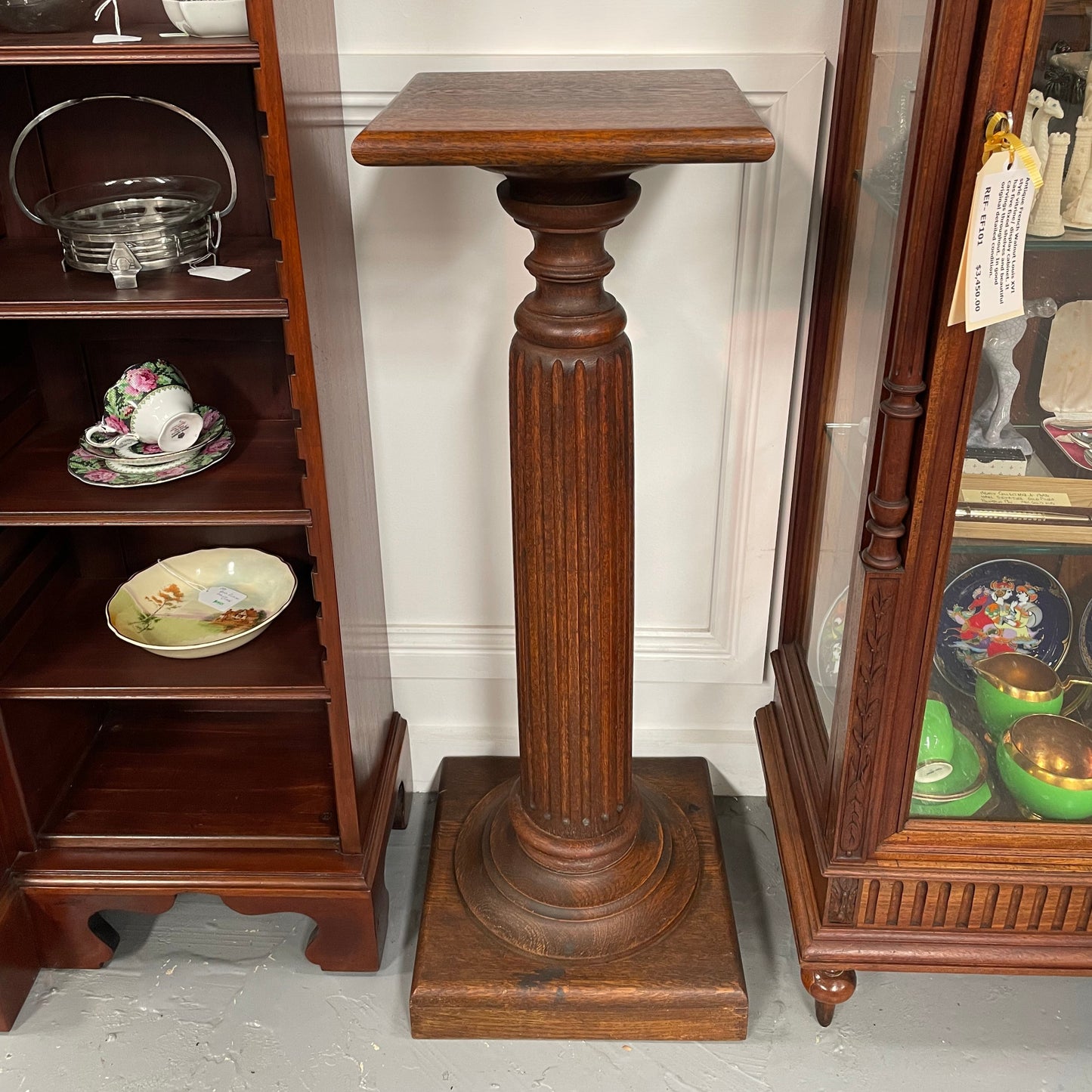 Edwardian oak pedestal with square top and base and featuring a fluted column. In good original condition. 