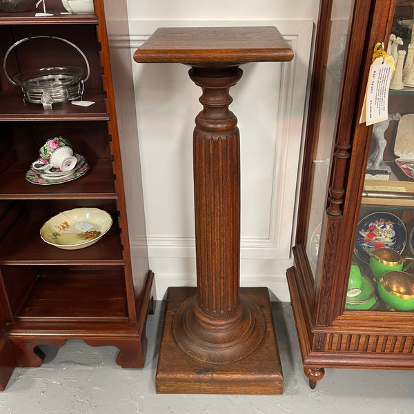 Edwardian oak pedestal with square top and base and featuring a fluted column. In good original condition. 