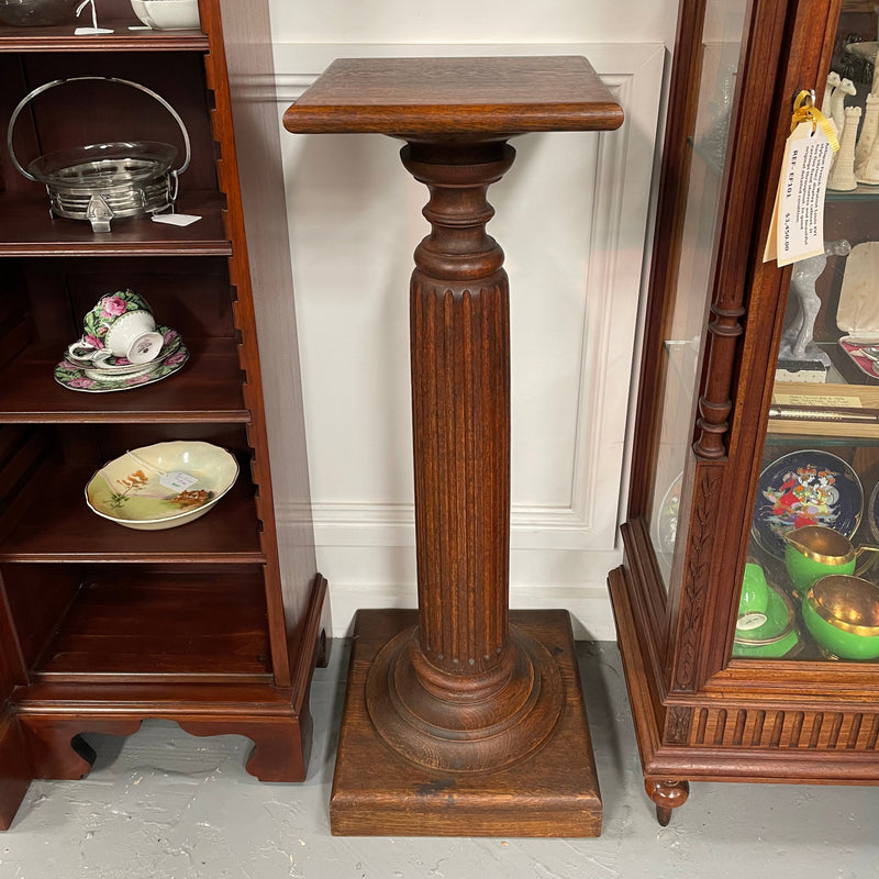Edwardian oak pedestal with square top and base and featuring a fluted column. In good original condition. 