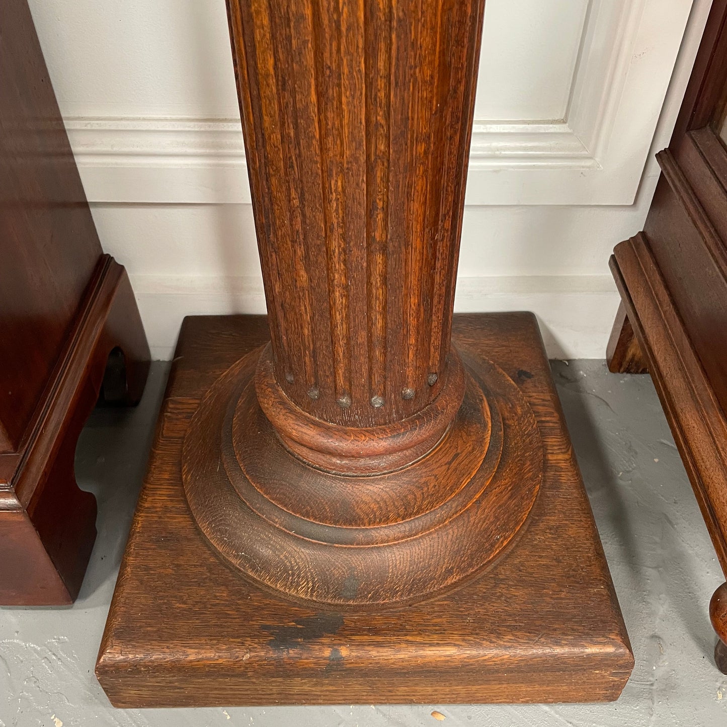 Edwardian oak pedestal with square top and base and featuring a fluted column. In good original condition. 