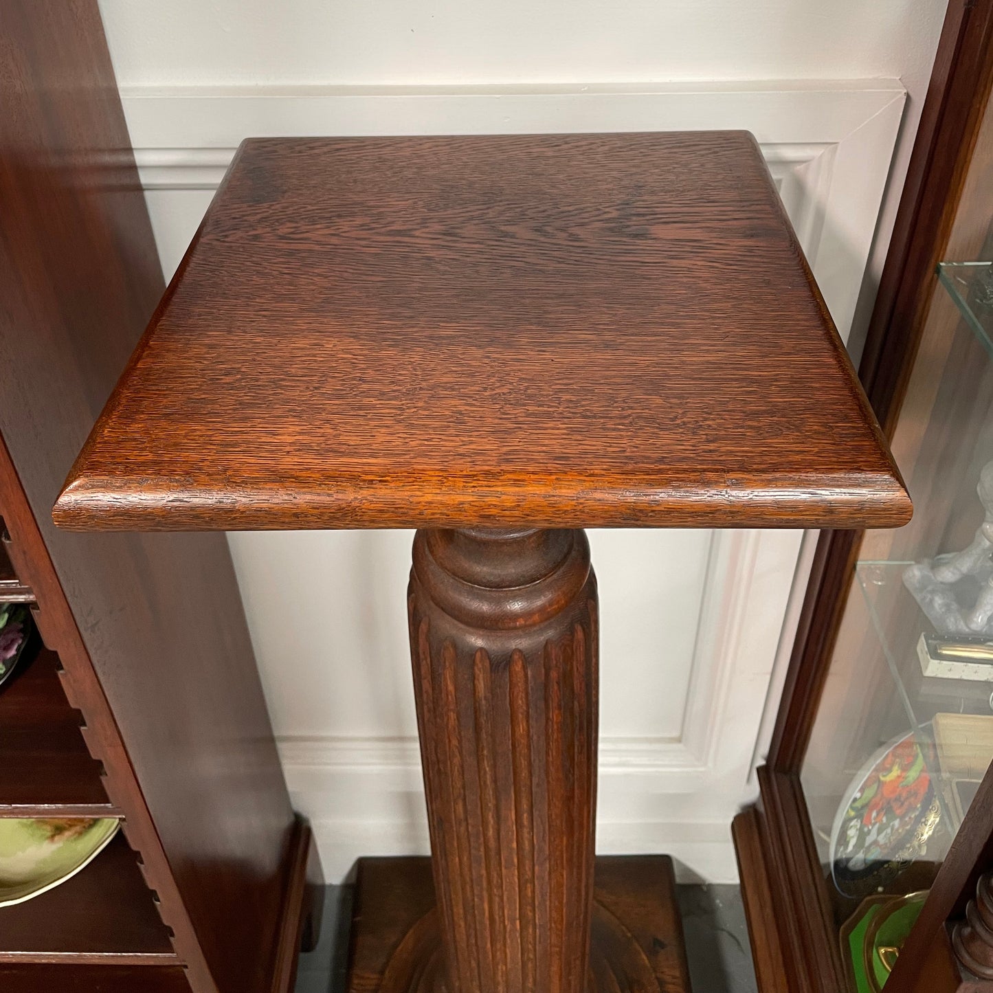 Edwardian oak pedestal with square top and base and featuring a fluted column. In good original condition. 