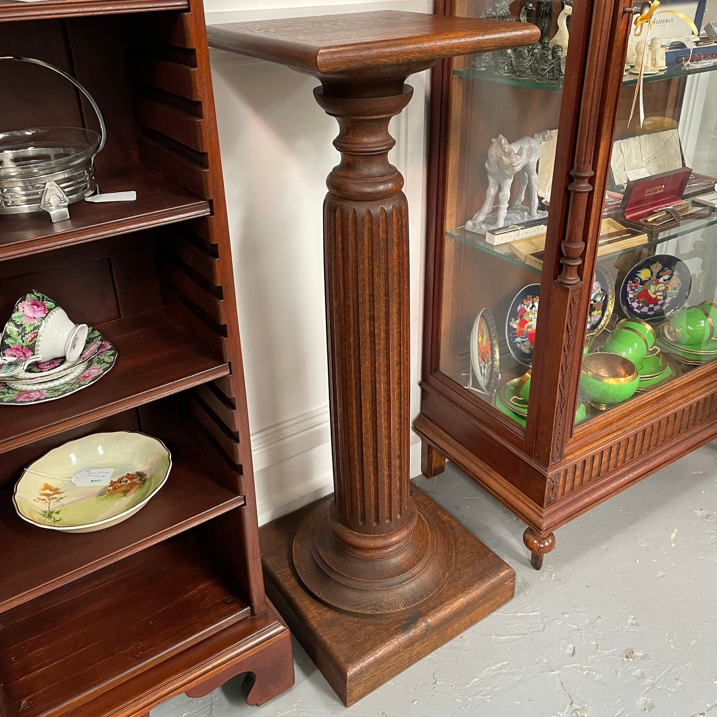 Edwardian oak pedestal with square top and base and featuring a fluted column. In good original condition. 