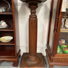 Edwardian oak pedestal with square top and base and featuring a fluted column. In good original condition. 