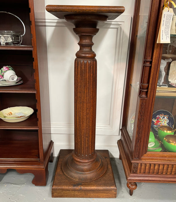 Edwardian oak pedestal with square top and base and featuring a fluted column. In good original condition. 