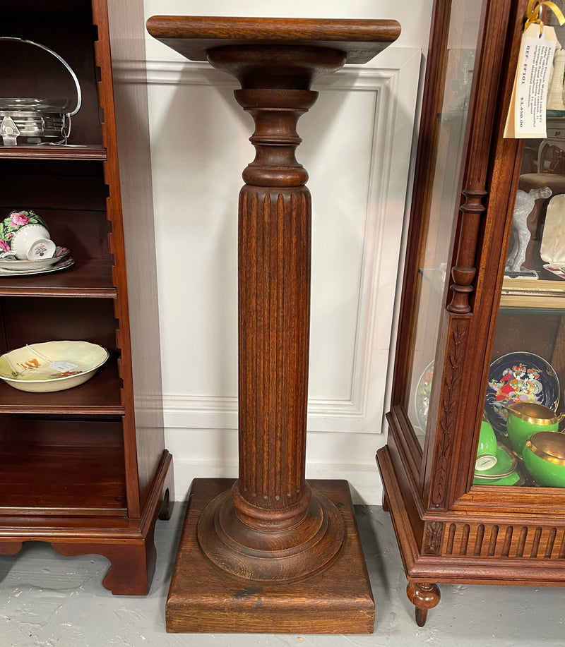 Edwardian oak pedestal with square top and base and featuring a fluted column. In good original condition. 