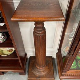 Edwardian oak pedestal with square top and base and featuring a fluted column. In good original condition. 