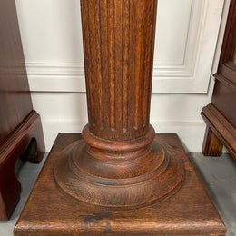 Edwardian oak pedestal with square top and base and featuring a fluted column. In good original condition. 