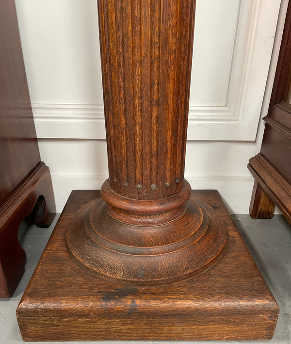 Edwardian oak pedestal with square top and base and featuring a fluted column. In good original condition. 