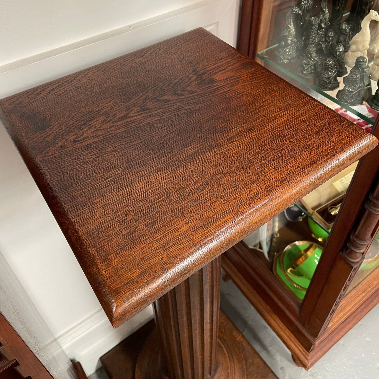 Edwardian oak pedestal with square top and base and featuring a fluted column. In good original condition. 
