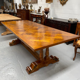 Vintage reclaimed Mahogany parquetry top monastery style dining table. It features beautiful brass mounts on the feet of the table and is in good original detailed condition. It can comfortably seat eight people. 