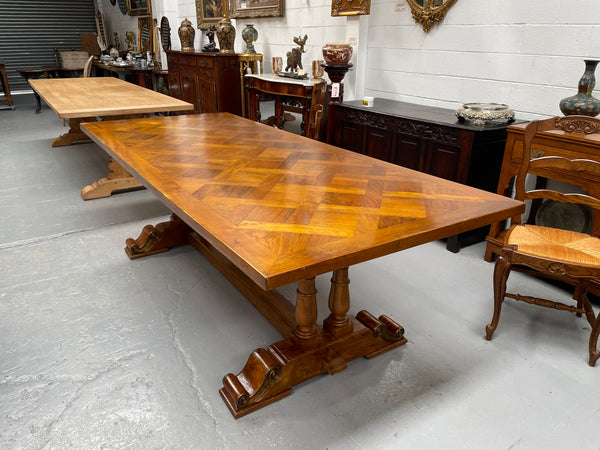 Vintage reclaimed Mahogany parquetry top monastery style dining table. It features beautiful brass mounts on the feet of the table and is in good original detailed condition. It can comfortably seat eight people. 