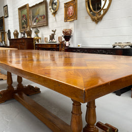 Vintage reclaimed Mahogany parquetry top monastery style dining table. It features beautiful brass mounts on the feet of the table and is in good original detailed condition. It can comfortably seat eight people. 