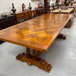 Vintage reclaimed Mahogany parquetry top monastery style dining table. It features beautiful brass mounts on the feet of the table and is in good original detailed condition. It can comfortably seat eight people. 