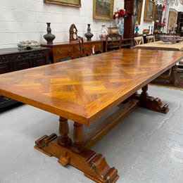 Vintage reclaimed Mahogany parquetry top monastery style dining table. It features beautiful brass mounts on the feet of the table and is in good original detailed condition. It can comfortably seat eight people. 