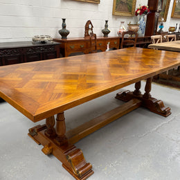 Vintage reclaimed Mahogany parquetry top monastery style dining table. It features beautiful brass mounts on the feet of the table and is in good original detailed condition. It can comfortably seat eight people. 