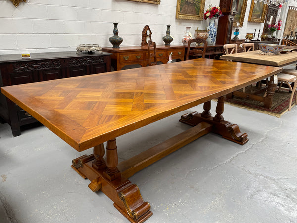 Vintage reclaimed Mahogany parquetry top monastery style dining table. It features beautiful brass mounts on the feet of the table and is in good original detailed condition. It can comfortably seat eight people. 