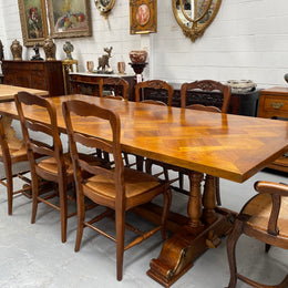 Vintage reclaimed Mahogany parquetry top monastery style dining table. It features beautiful brass mounts on the feet of the table and is in good original detailed condition. It can comfortably seat eight people. 