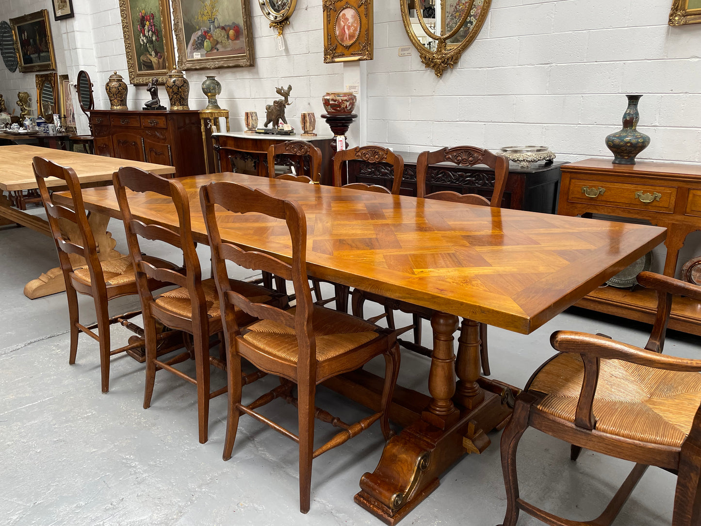 Vintage reclaimed Mahogany parquetry top monastery style dining table. It features beautiful brass mounts on the feet of the table and is in good original detailed condition. It can comfortably seat eight people. 