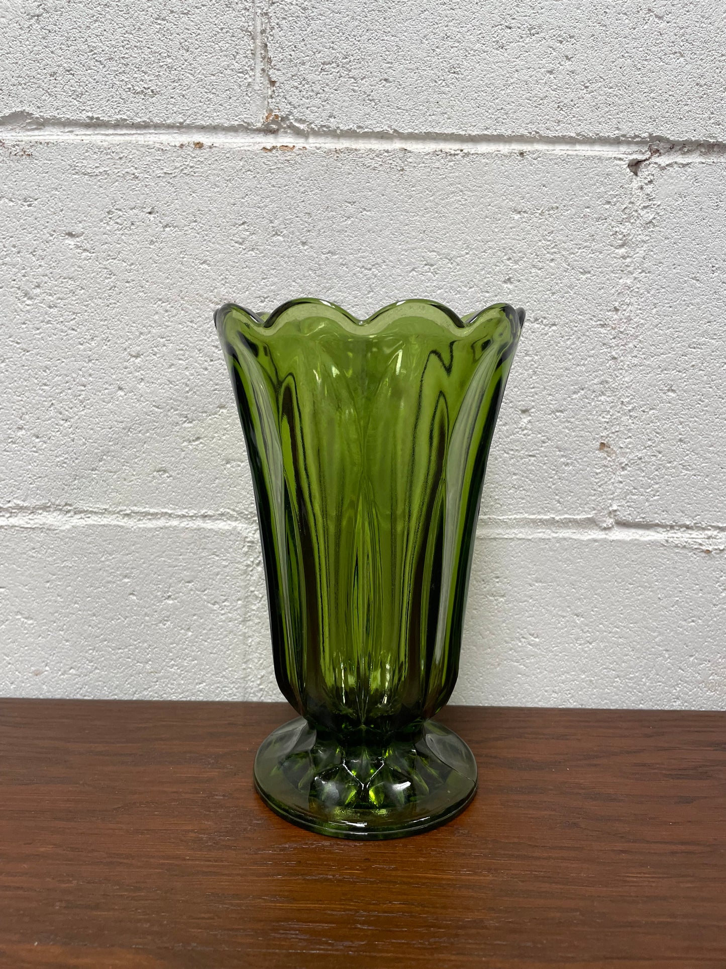 Lovely vintage green glass vase with a pretty scalloped edge and good height for flowers.