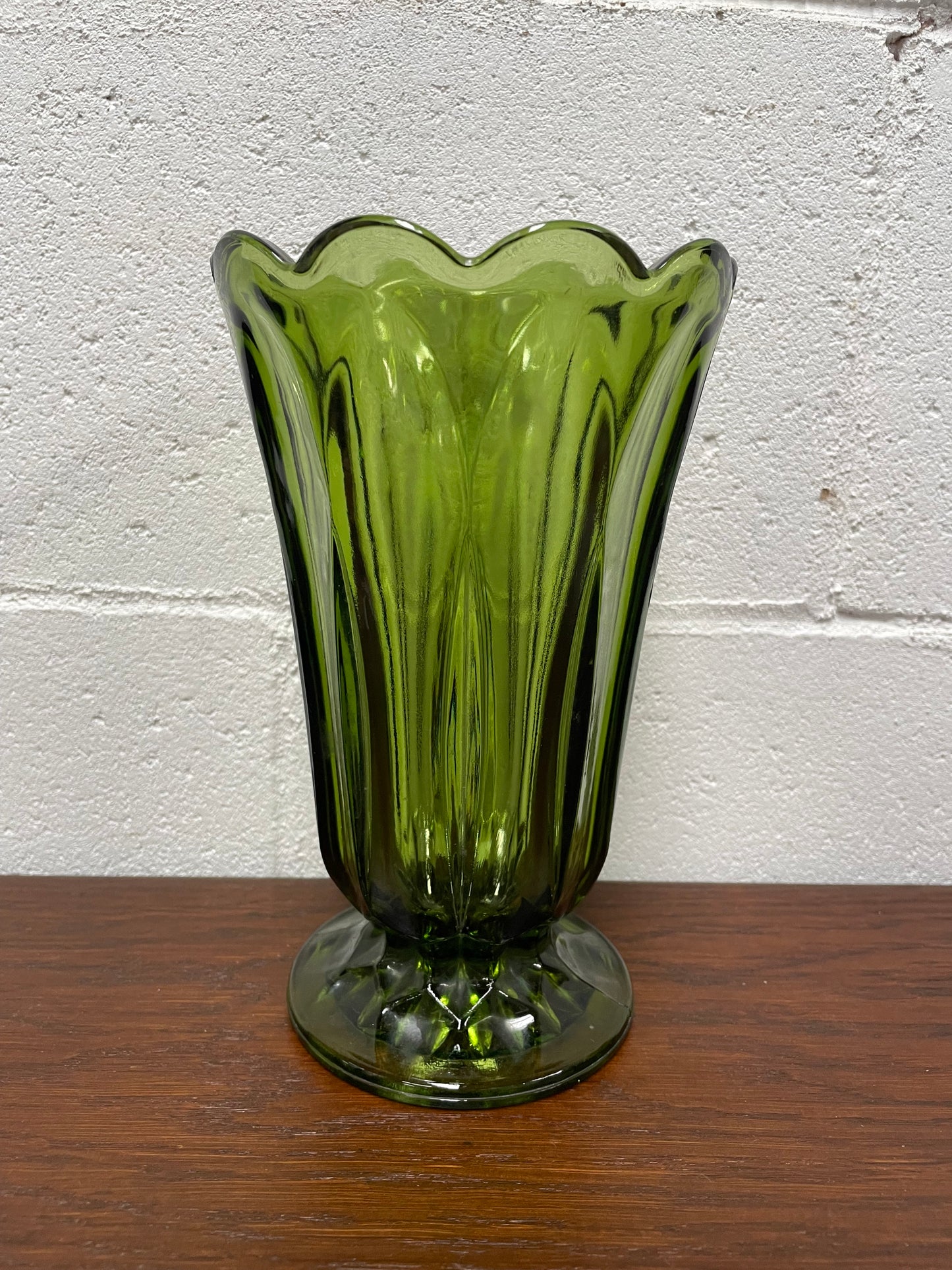 Lovely vintage green glass vase with a pretty scalloped edge and good height for flowers.