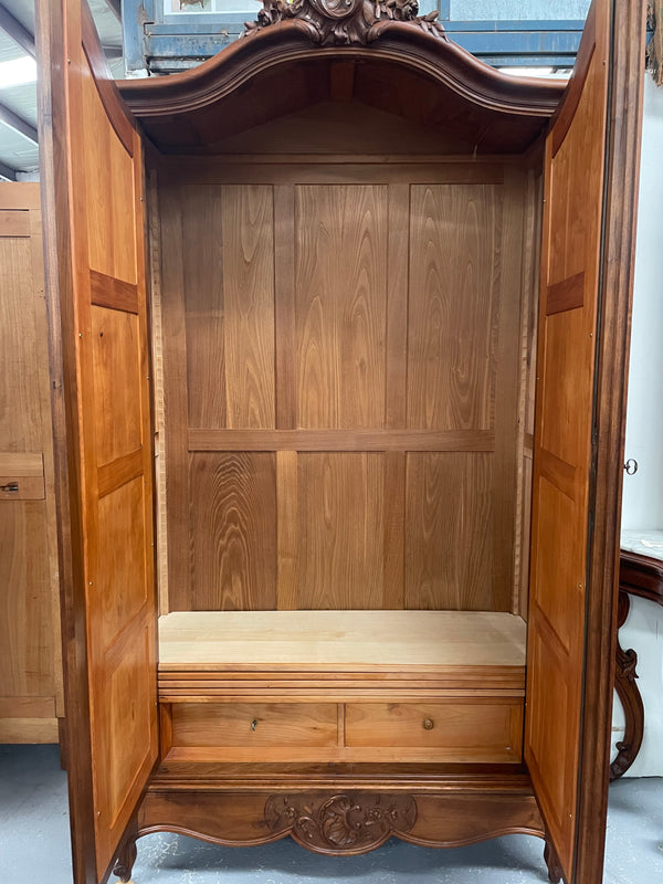 French Walnut Louis XV style two mirrored door armoire. It has four full adjustable shelves and two drawers at the bottom with one that locks. It has been sourced directly from France and is in good original detailed condition.