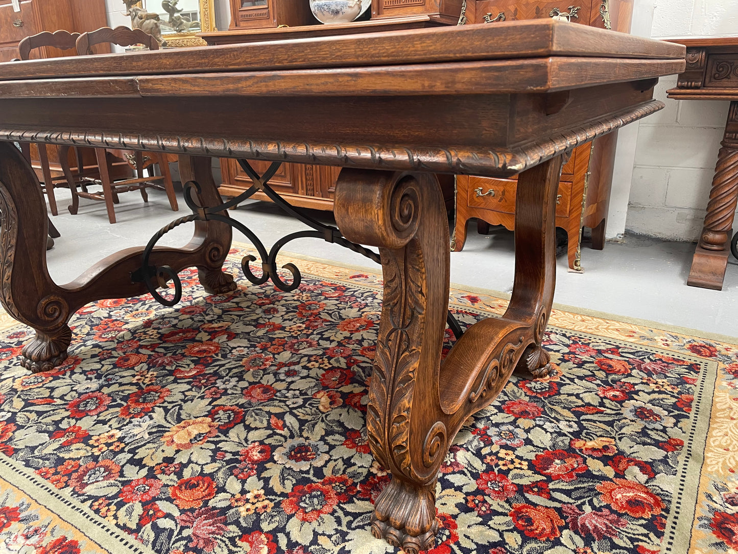 Beautiful French Oak Spanish style extension dining table with a decorative iron base and parquetry top. Lovely carvings on the legs and the skirt of the base.  With the extensions closed it is 160 cm long and when fully extended it is 268 cm long. It has been sourced from France and in good original condition.