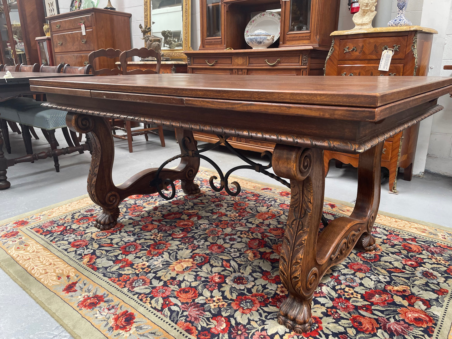 Beautiful French Oak Spanish style extension dining table with a decorative iron base and parquetry top. Lovely carvings on the legs and the skirt of the base.  With the extensions closed it is 160 cm long and when fully extended it is 268 cm long. It has been sourced from France and in good original condition.