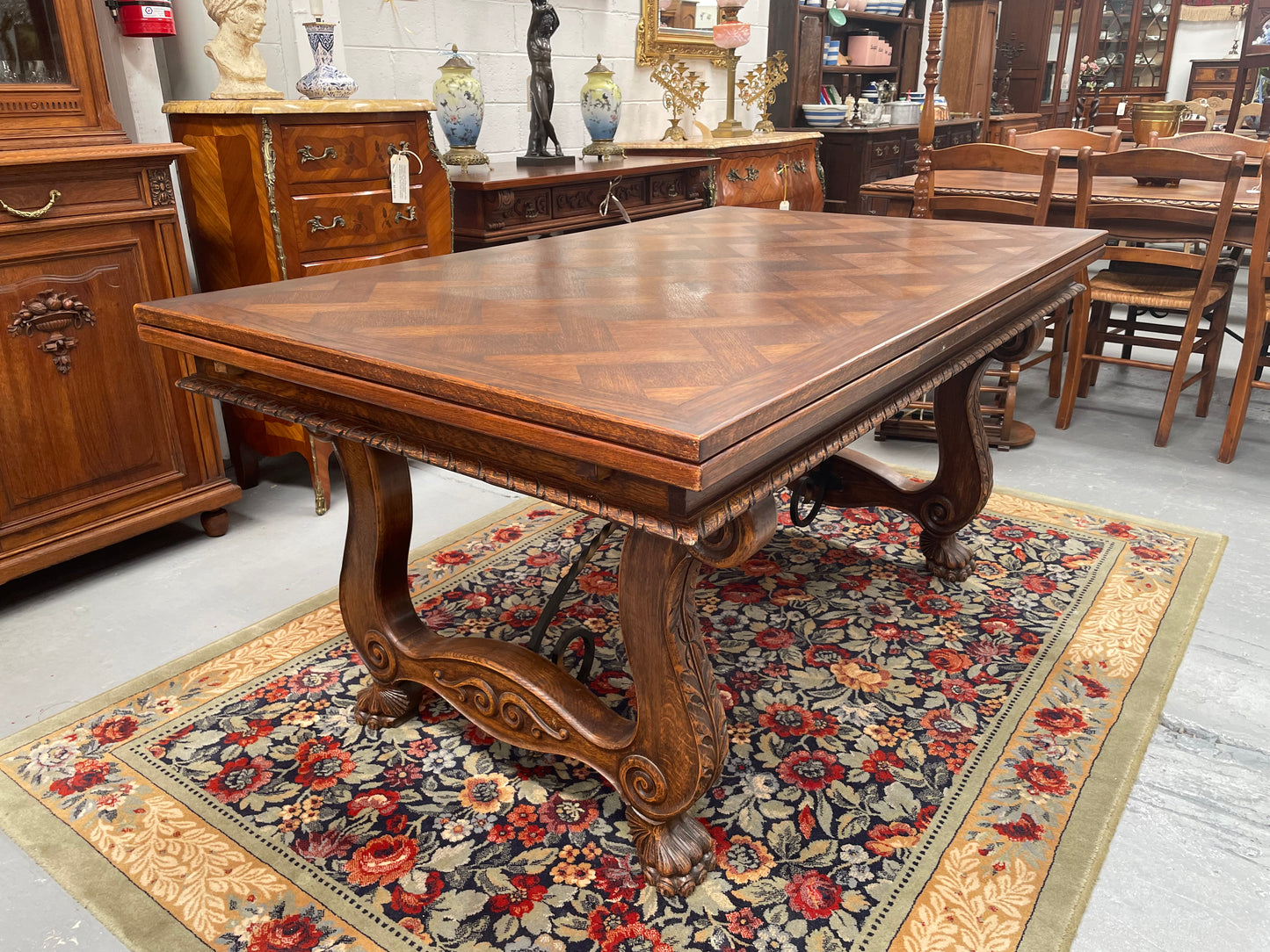 Beautiful French Oak Spanish style extension dining table with a decorative iron base and parquetry top. Lovely carvings on the legs and the skirt of the base.  With the extensions closed it is 160 cm long and when fully extended it is 268 cm long. It has been sourced from France and in good original condition.