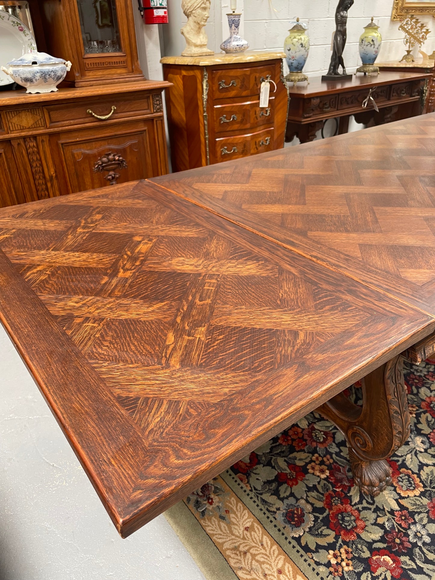 Beautiful French Oak Spanish style extension dining table with a decorative iron base and parquetry top. Lovely carvings on the legs and the skirt of the base.  With the extensions closed it is 160 cm long and when fully extended it is 268 cm long. It has been sourced from France and in good original condition.