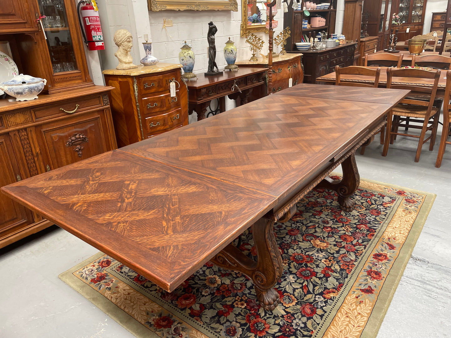 Beautiful French Oak Spanish style extension dining table with a decorative iron base and parquetry top. Lovely carvings on the legs and the skirt of the base.  With the extensions closed it is 160 cm long and when fully extended it is 268 cm long. It has been sourced from France and in good original condition.