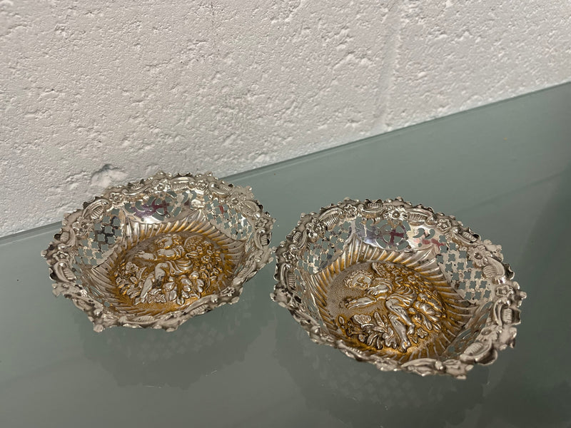 Lovely pair of sterling silver and silver gilt Edwardian bon bon dishes with decorative cherubs and in good original condition. Please see photos as they form part of the description.