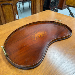Wooden tray with decorative inlay on a wooden surface