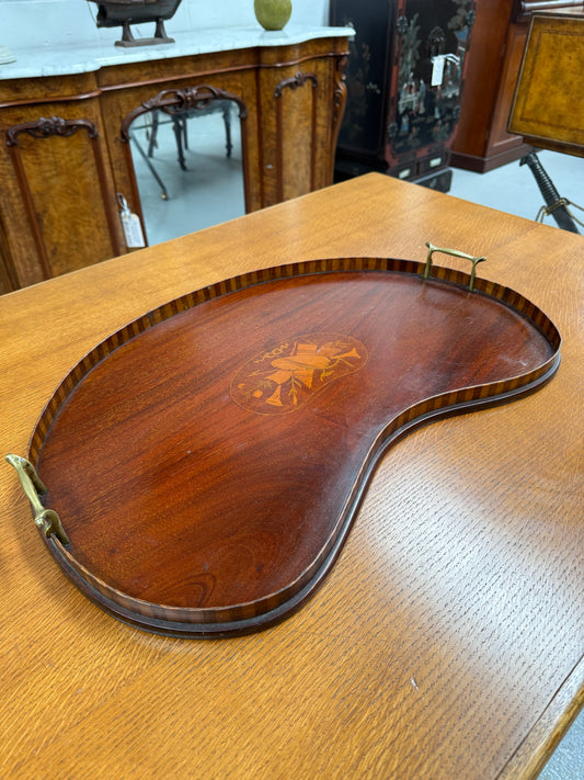 Wooden tray with decorative inlay on a wooden surface
