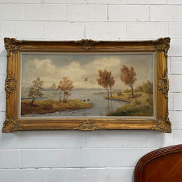 Beautiful large French oil on canvas landscape of a peaceful river scene featuring ducks and trees in a ornate gold frame. Sourced from France and in good original condition.