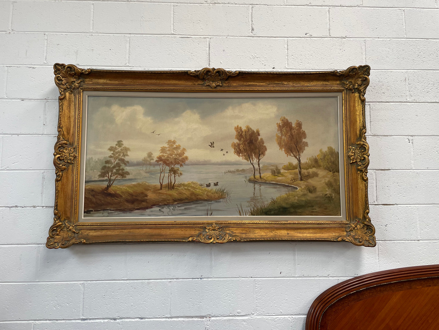 Beautiful large French oil on canvas landscape of a peaceful river scene featuring ducks and trees in a ornate gold frame. Sourced from France and in good original condition.