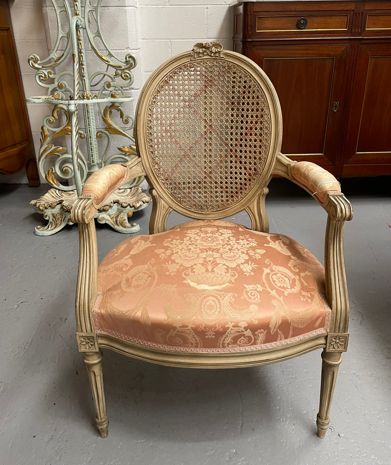 French Louis XV style cane back and upholstered seat fauteuil. With original paint and fabric is in original used condition with some stains and tears. Overall they are in good original used condition. Circa 1950's.